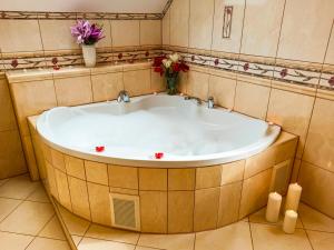 卡尔帕奇Apartamenty i Pokoje u Doroty的浴室设有大浴缸,并装饰有鲜花。