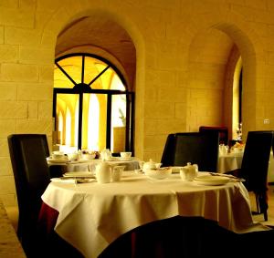 Squinzano马塞里亚圣保罗酒店的一间用餐室,配有餐桌和餐具