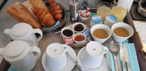 圣特罗让莱班Hotel et Spa Les Cleunes Oléron的一张桌子,上面放着羊角面包、咖啡和面包
