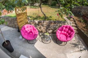 罗维尼Sweet的庭院里摆放着三把粉红色的椅子