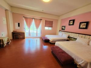 台东草莓牛奶台東民宿可洽包棟的大房间设有两张床和窗户