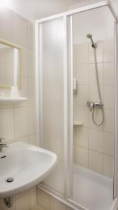 拉姆绍达赫斯坦斯蒂埃勒酒店的带淋浴和盥洗盆的白色浴室