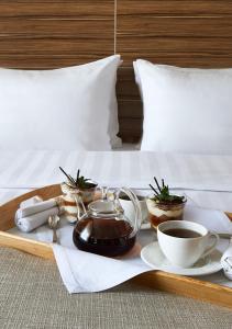 莫斯科伊兹麦洛娃三角洲酒店的床上的茶壶和杯子托盘