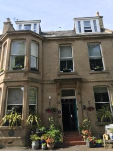 爱丁堡敖彬别墅酒店的一座种植了植物的古老房子