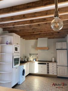 坎波德克里普塔纳Casa Rural Abuelo Teo的一间厨房,配有白色家电和木制天花板