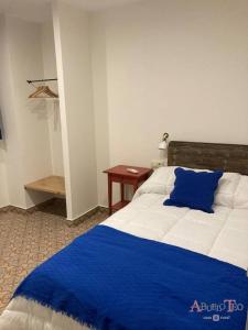 坎波德克里普塔纳Casa Rural Abuelo Teo的卧室配有蓝色和白色的床和一张桌子