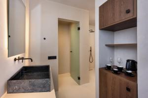梅加洛克里Azanti Suites - Adults Only的一间带水槽和镜子的浴室