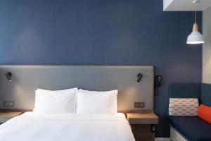 珠海珠海拱北智选假日酒店的一间卧室设有一张大床和蓝色的墙壁