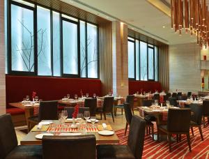 班加罗尔Welcomhotel by ITC Hotels, Richmond Road, Bengaluru的用餐室设有桌椅和窗户。