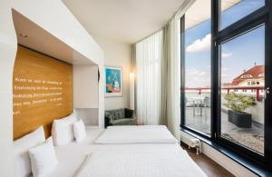 莱比锡Art Hotel City Leipzig的一间卧室设有一张床和一个大窗户