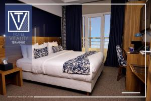 盖尼特拉Hotel Vitality Terminus的酒店附近的客房配有一张床和一张书桌。