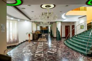 尼古拉耶夫乌克兰皇宫酒店的大堂设有楼梯和吊灯