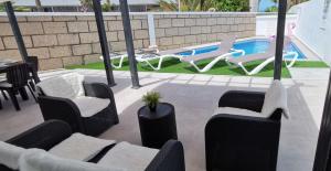 卡亚俄萨尔瓦赫Villa Orquídea的一个带椅子的庭院和一个游泳池