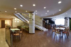叶卡捷琳堡Voznesensky Hotel的一间带桌椅的餐厅,以及楼梯