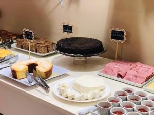 尤西德福拉Hotel Centenário的一张桌子,上面摆放着各种蛋糕和糕点