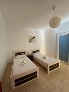 卡萨米尔Hotel Villa Ruci的白色客房的两张床,设有窗户