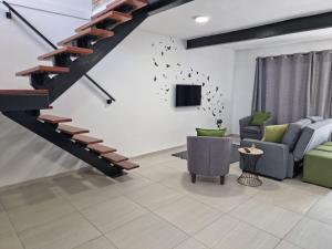 鲁德普特Wilgespruit Manor Flat的客厅设有楼梯、沙发和电视