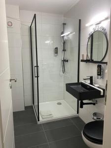 曼海姆Hotel am Hafen的一间带玻璃淋浴和水槽的浴室