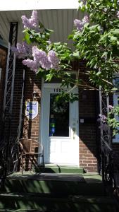 魁北克市特朗斯特住宿加早餐酒店的白色的门,上面有紫色的花