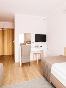 梅斯瓦科维采查塔扎维希亚酒店的酒店客房设有一张床和一张带电视的书桌。