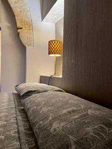 莱切Cuore Barocco的一间卧室配有一张床,墙上配有一盏灯