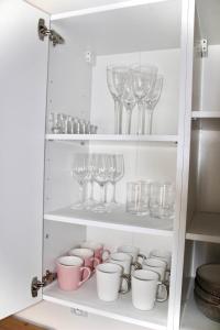 厄尔科Tani Nocleg Ełk - Apartament I love Ełk的装满玻璃杯和酒杯的橱柜
