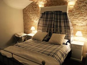 LimalongesLe Logis de Limalonges的一间卧室配有一张带床头板的床和两盏灯。