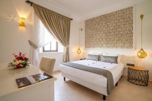 马拉喀什Marrakech Ryads Parc All inclusive的配有一张床和一张书桌的酒店客房