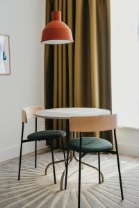 海牙Hotel Bries Den Haag - Scheveningen的一张桌子和两把椅子以及一盏灯