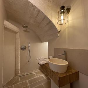 奥斯图尼Caterina's Suites & Apartament的一间带水槽和淋浴的浴室