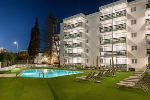 英格兰海滩Roca Verde - Playa del Inglés的一座公寓楼,晚上设有游泳池
