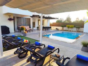 拉纳卡Ilios Villa的一个带椅子的庭院和一个游泳池