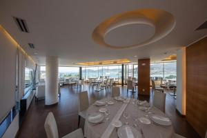 比韦罗Hotel Thalasso Cantabrico Las Sirenas 4 Superior的用餐室配有带酒杯的桌子