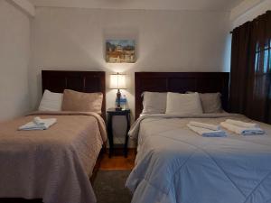 康塞普西翁德阿塔科Hotel & Restaurant Fleur de Lis的一间卧室配有两张带毛巾的床