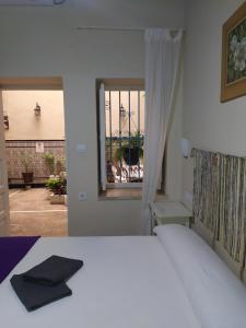 塞维利亚金橙花旅馆的一间卧室设有一张床和一个窗口