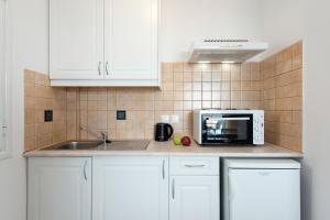 格利法达Corfu Amboti Apt的厨房配有白色橱柜和微波炉