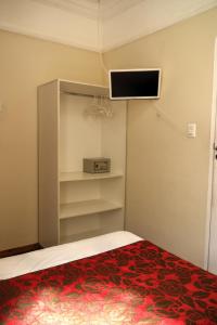 萨尔瓦多Pousada Acácia da Barra的卧室配有一张床,墙上配有电视。
