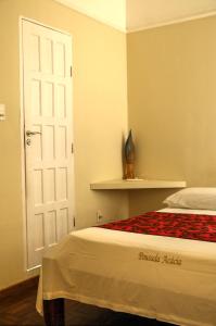 萨尔瓦多Pousada Acácia da Barra的卧室配有床和白色门