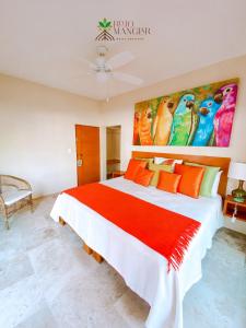 阿卡普尔科Rojo Manglar Acapulco的卧室配有一张大床,墙上挂有绘画作品