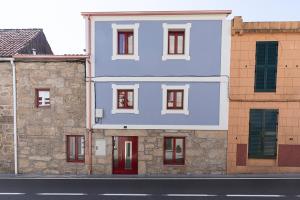帕德隆A Casa Antiga do Monte Apartamentos Turísticos - Lestrove的街上有红色门的蓝色建筑