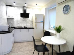 克洛佩夫尼茨基Apart Gagarina 7的厨房配有白色桌子和白色冰箱。