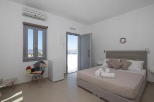 阿克罗蒂里锡拉岛海豚酒店的一间卧室配有一张床、一张桌子和一把椅子