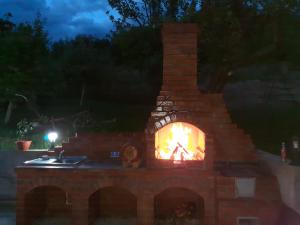 阿尔杰什河畔库尔泰亚Casa Alex的砖砌壁炉,晚上火烧