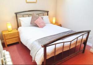 比格尔斯威德Stratton Cottage Guesthouse的一间卧室配有一张带两张台灯的床铺。