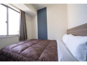 福冈R&B Hotel Hakata Ekimae 2 - Vacation STAY 40724v的一间卧室设有一张床和一个大窗户