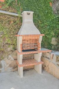 奥利维拉多霍斯比托Casa dos Cabecinhos的砖炉,坐在长凳上