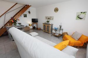 Châteauneuf-de-GalaureLes Figuets的客厅配有白色沙发和橙色家具