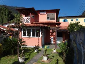 阿布拉奥Pousada Arrastão da Ilha的前面有植物的粉红色房子