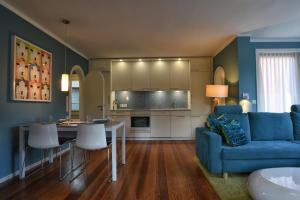 威克奥夫弗尔Haus Lene的一间带蓝色沙发的客厅和一间厨房