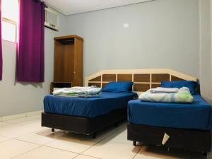 圣保罗普拉查俄里翁酒店的一间卧室配有两张蓝色床单